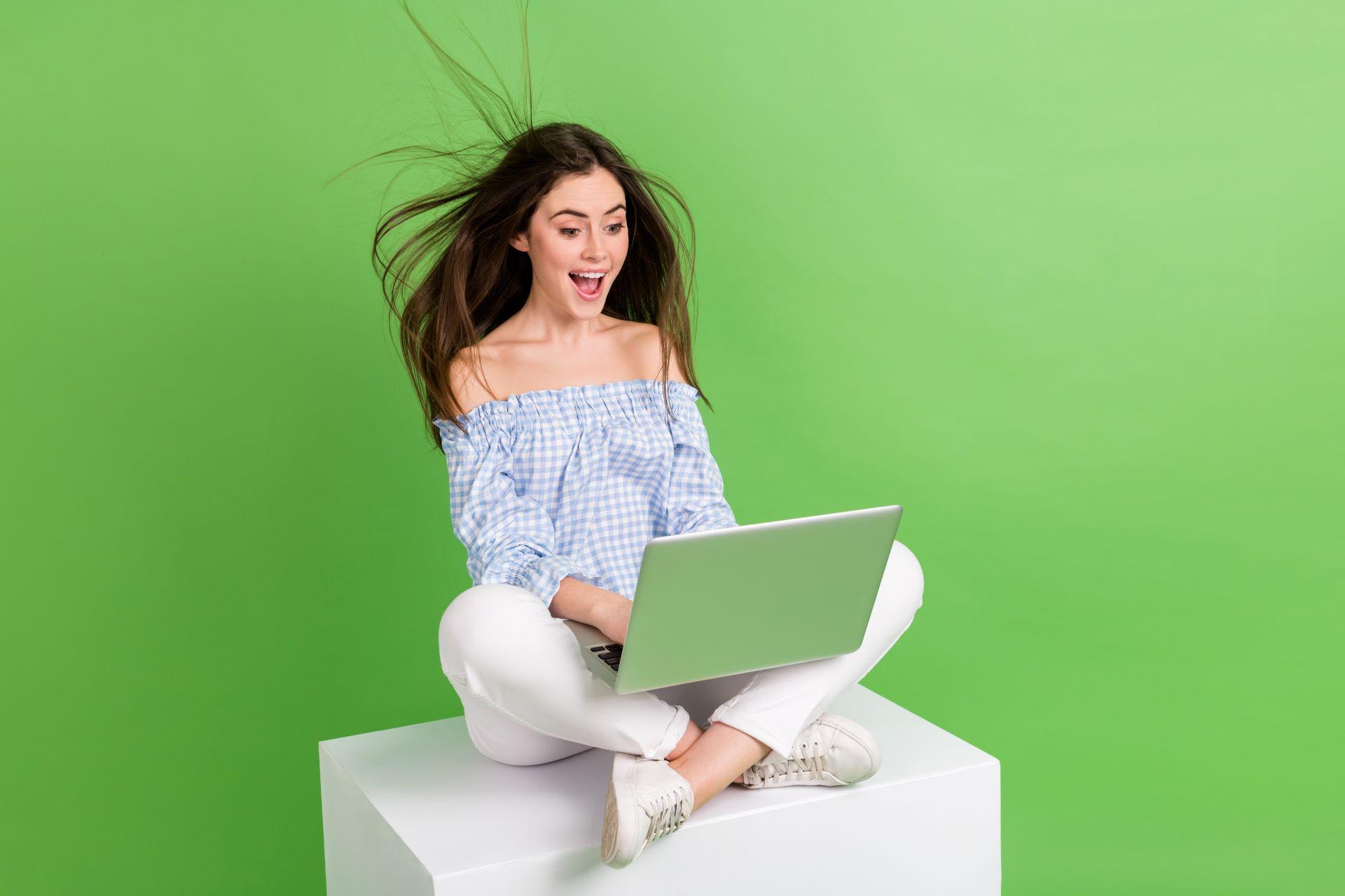 Eine begeisterte Frau nutzt ihren Laptop, um stressfreies Online-Shopping mit einer stabilen Multimode-Internetverbindung zu genießen.