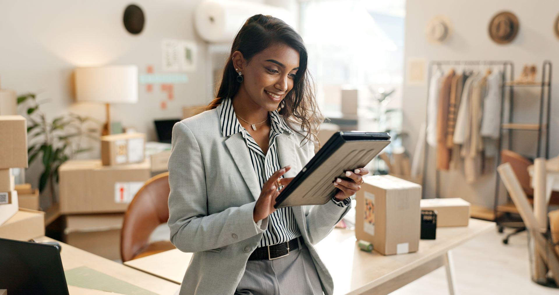 Eine Geschäftsfrau nutzt ein Tablet, um ihre E-Commerce-Strategie in einem modernen Büro mit stabiler Multimode-Internetverbindung zu optimieren.
