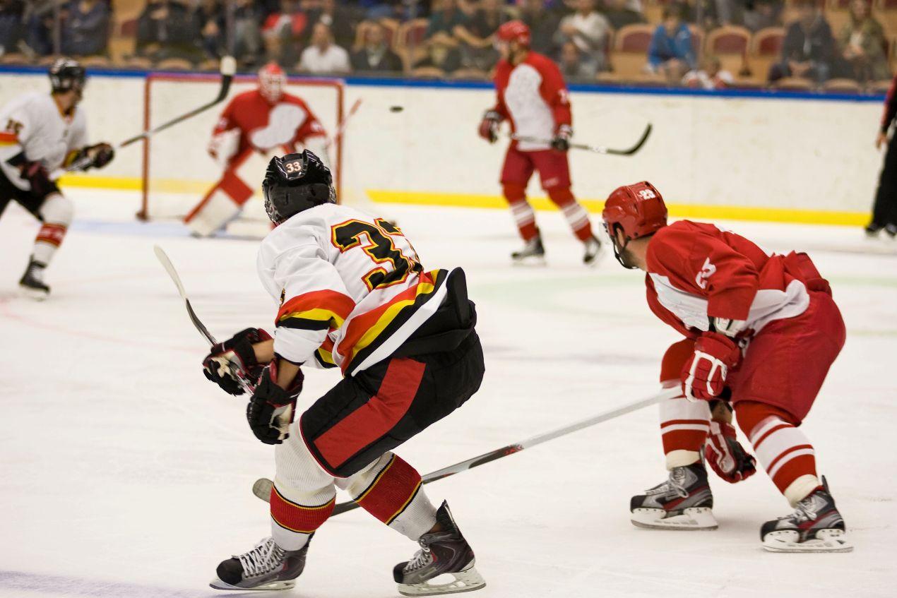 Eishockey Puck im Fokus bei Spielsituation mit zwei Mannschaften in einer Eishalle