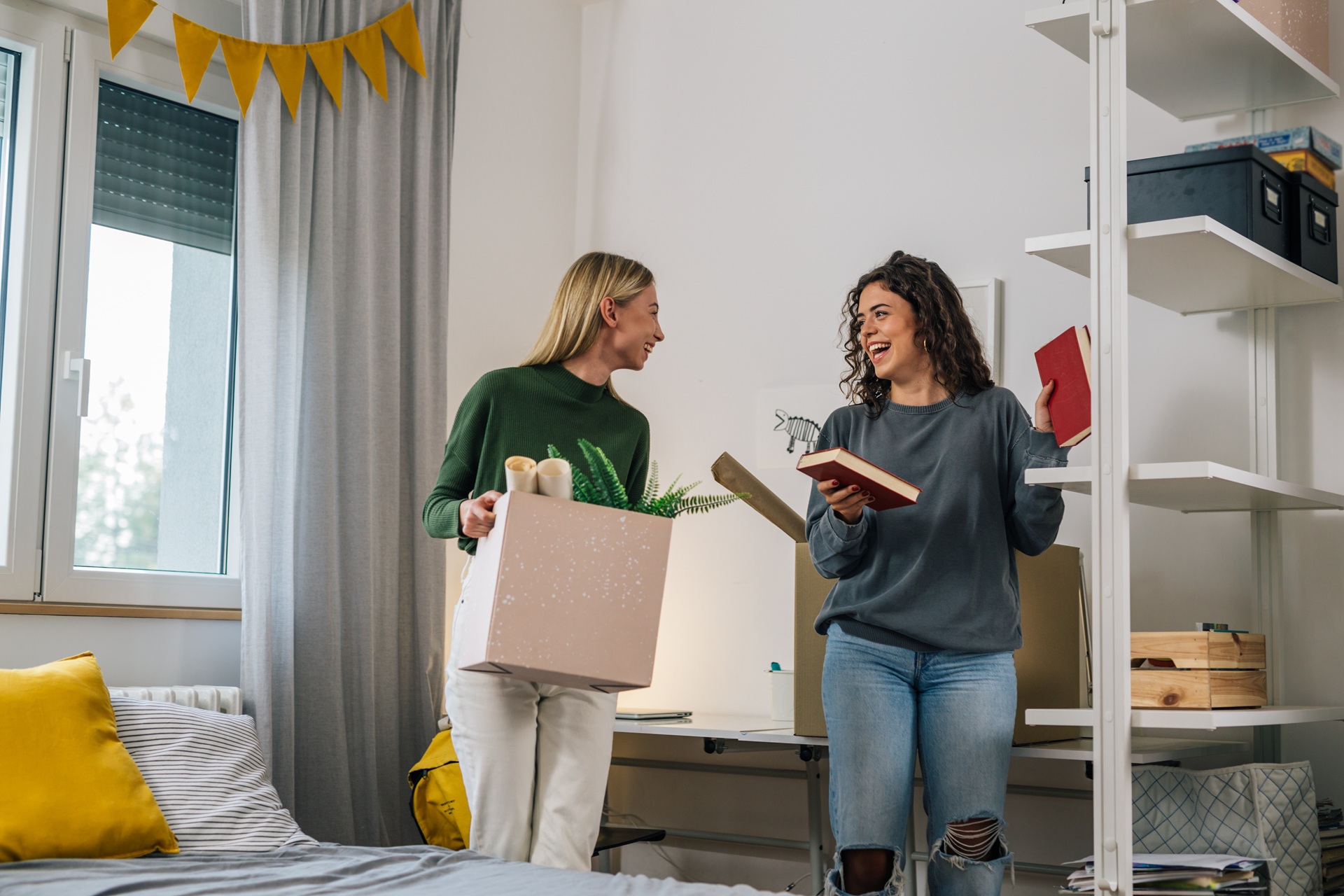 Junge Frauen richten ihr Studentenzimmer ein | Einzelbett