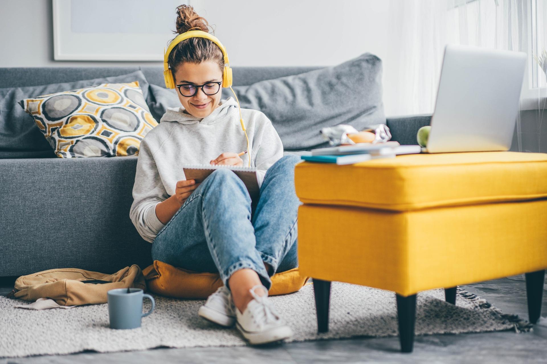 Studentin arbeitet entspannt mit Laptop und Notizen | Einzelbett