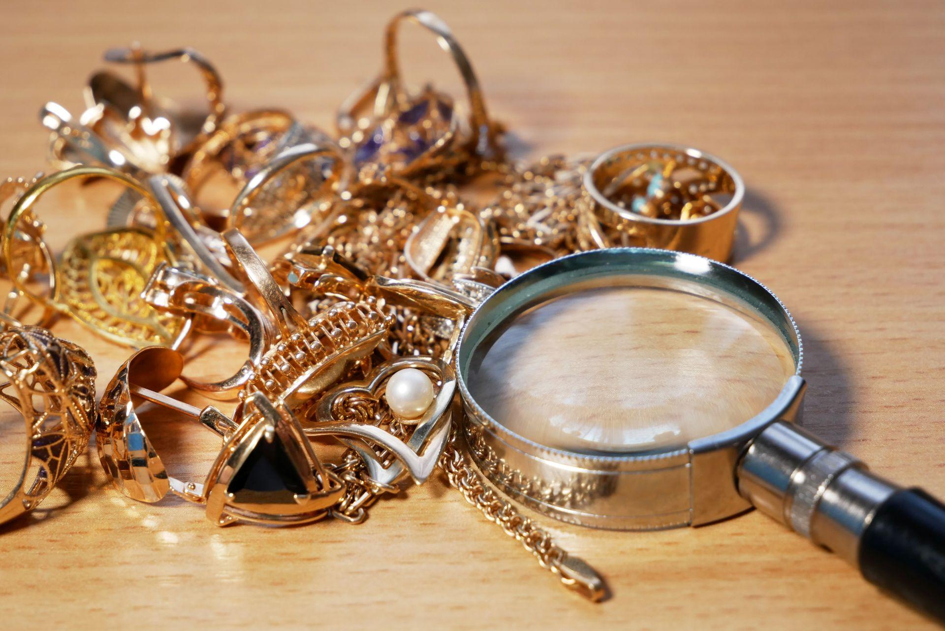 goldschmuck mit lupe auf tisch untersucht detailreiche einzelstuecke